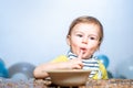 Babies eating, healthy food for a baby. Funny kid boy with plate and spoon. Royalty Free Stock Photo