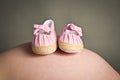 Babies first shoes on a pregnant womans bump Royalty Free Stock Photo