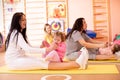 Babies have fun while mothers doing workout in gym class to loose extra weight. Child-friendly fitness for women with Royalty Free Stock Photo