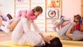 Babies have a fun while mothers doing workout in gym class to loose extra weight. Child-friendly fitness for women with