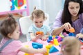 Babies in kindergarten. Kids toddlers in nursery school. Little children preschoolers play with teacher. Royalty Free Stock Photo