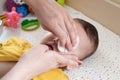 babies and newborn hygiene and healthcare. Closeup of cleaning and washing baby face with soft cottong pad Royalty Free Stock Photo