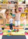 Babies toddlers playing with colorful educational toys together with mothers in nursery room Royalty Free Stock Photo