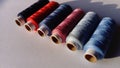 Baboons and spools of thread in different colors. White background. Blue, red, pink, gray, black. Close - up Royalty Free Stock Photo