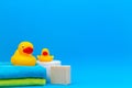 Baby accessories for bath with yellow rubber ducks on blue background Royalty Free Stock Photo