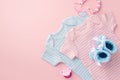 Baby accessories concept. Top view photo of pink and blue infant clothes bodysuits knitted booties and pacifier chain on isolated Royalty Free Stock Photo