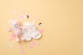 Baby accessories concept. Top view photo of pink knitted teddy-bear toy socks and shiny confetti on isolated pastel beige Royalty Free Stock Photo