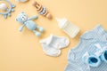 Baby accessories concept. Top view vertical photo of blue shirt knitted booties milk bottle socks wooden rattle knitted teddy-bear Royalty Free Stock Photo