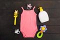 Baby accessories - pink bodysuit, soap, pacifier and rattle over wooden background Royalty Free Stock Photo