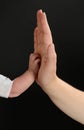 Baby and adult hands clashing. Body parts isolated on black background.