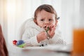 Baby, angry child and eating vegetables in home for health, wellness and nutrition. Upset kid, high chair and food Royalty Free Stock Photo