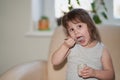 The baby with an appetite eats baby puree from a jar. She lifted the food spoon to her open mouth. Selective focus