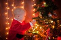 The baby around the Christmas tree with lights