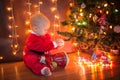 The baby around the Christmas tree with lights