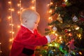 The baby around the Christmas tree with lights