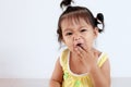 Baby asian child girl eating noodle by herself and making a mess on her face and hand Royalty Free Stock Photo