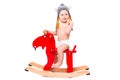 Baby in Asterix hat on the toy elk Royalty Free Stock Photo