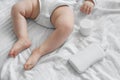 Baby and baby milk and cream. Sensitive baby skin. Newborn baby on a white bed Royalty Free Stock Photo