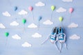 Baby background with balloons, white clouds and baby boy shoes on blue wooden background Royalty Free Stock Photo