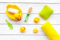 Baby bath set with yellow rubber duck. Soap, sponge, brushes, towel on white wooden background top view Royalty Free Stock Photo