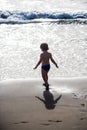 Baby on the beach. Lonely vacation. A boy goes into the water of the ocean. Beautiful black beach in Tenerife. Black