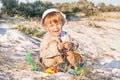 Baby is at the beach with sand dunes. Royalty Free Stock Photo