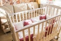 Baby bed crib with white and Burgundy color pillows with laces Royalty Free Stock Photo