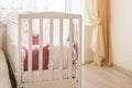 Baby bed crib with white and Burgundy color pillows with laces Royalty Free Stock Photo