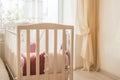 Baby bed crib with white and Burgundy color pillows with laces Royalty Free Stock Photo