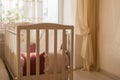 Baby bed crib with white and Burgundy color pillows with laces Royalty Free Stock Photo