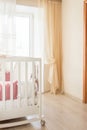 Baby bed crib with white and Burgundy color pillows with laces Royalty Free Stock Photo