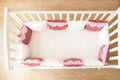 Baby bed crib with white and Burgundy color pillows with laces Royalty Free Stock Photo