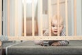 Baby behind safety gates in front of stairs