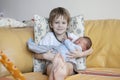Baby being held tenderly by big brother