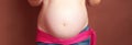 Baby belly against brown background