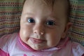 Baby with big blue eyes with an interesting expression raspberry. Royalty Free Stock Photo