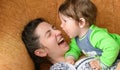 Baby bites moms nose. Happy mother with baby. A boy bites his mothers nose on the couch. having fun with your beloved mother Royalty Free Stock Photo