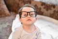 Baby in black glasses. close-up. Poor vision in a child