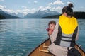 Baby Blowing Whistle in Canoe With Mother