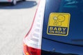 Baby on board  warning sign text on rear windows car in street Royalty Free Stock Photo