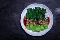 Baby Bok choy or chinese cabbage in oyster sauce with fried garlic. on black background Royalty Free Stock Photo