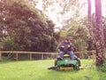 Baby boomer mowing grass on ride on mower