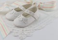 Baby booties background with white lace and pastel colour ribbon
