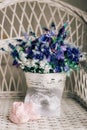 Baby booties on a wicker chair and a bouquet of lavender on a ba Royalty Free Stock Photo