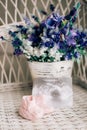 Baby booties on a wicker chair and a bouquet of lavender on a ba Royalty Free Stock Photo