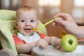 Baby eating healthy food with father help at home Royalty Free Stock Photo