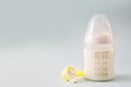 Baby bottle and milk on gray background