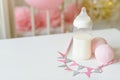 Baby bottles with breast milk with various festive paper decor. It`s a girl or baby birthday celebration concept. Royalty Free Stock Photo