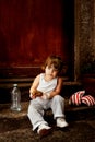 Baby boxer sitting on the steps with a piece of bread in the hand