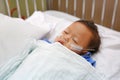 Baby boy age about 1 year old sleeping on patient bed with getting oxygen via nasal prongs to assure oxygen saturation. Intensive